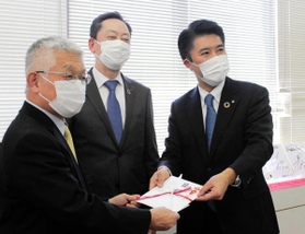 泉市長に目録を手渡す信金中央金庫神戸支店の関口支店長(右端)と日新信用金庫の山本良一理事長(中央)=明石市役所 泉市長に目録を手渡す信金中央金庫神戸支店の関口支店長(右端)と日新信用金庫の山本良一理事長(中央)=明石市役所