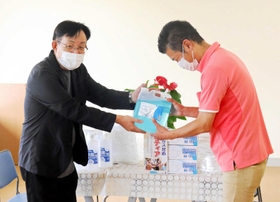 衛生用品を手渡す、明石理容組合の中尾博之会長(左)=明石市魚住町錦が丘2 衛生用品を手渡す、明石理容組合の中尾博之会長(左)=明石市魚住町錦が丘2