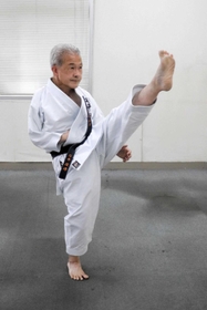 右手を胴着に入れ、上段蹴りの練習をする石井啓友さん=明石市内 右手を胴着に入れ、上段蹴りの練習をする石井啓友さん=明石市内
