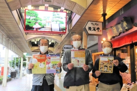 新しく設置されたデジタルサイネージの前でイベントをPRする明石銀座商店街の商店主=明石市桜町