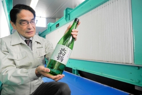 もろみ搾り機の隣で大和鶴を手にする薮田亘康社長=明石市大久保町西島 もろみ搾り機の隣で大和鶴を手にする薮田亘康社長=明石市大久保町西島