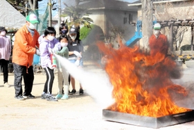 消火器を使って炎を消し止める参加者=明石市魚住町西岡 消火器を使って炎を消し止める参加者=明石市魚住町西岡