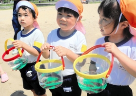 放流前にヒラメの稚魚を持つ園児たち=明石市二見町東二見 放流前にヒラメの稚魚を持つ園児たち=明石市二見町東二見