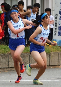 明石北の1区・稲富早紀選手(左)からたすきを受け取る2区・直江詩選手=西脇市総合市民センター(撮影・笠原次郎) 明石北の1区・稲富早紀選手(左)からたすきを受け取る2区・直江詩選手=西脇市総合市民センター(撮影・笠原次郎)