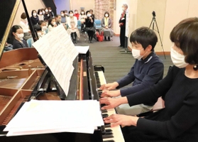 本番に備えて連弾曲を練習する出演者ら=洲本市文化体育館 本番に備えて連弾曲を練習する出演者ら=洲本市文化体育館