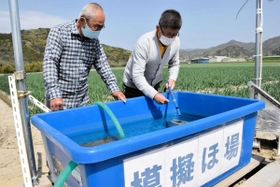 稲作の時期を前に、田んぼに見立てた水槽で自動給水装置の作動を確かめる住人ら=南あわじ市賀集福井 稲作の時期を前に、田んぼに見立てた水槽で自動給水装置の作動を確かめる住人ら=南あわじ市賀集福井
