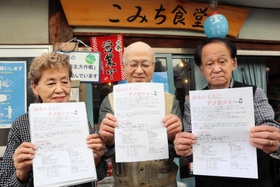 歌碑の設置予定地で資金集めのチラシを持つ、願う会の脇村富男さん(中央)と柿原寛さん(右)、紀田知美さん=洲本市本町6 歌碑の設置予定地で資金集めのチラシを持つ、願う会の脇村富男さん(中央)と柿原寛さん(右)、紀田知美さん=洲本市本町6