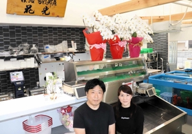 移転した新店舗に立つ花野光彦さんと妻の温子さん=洲本市本町4 移転した新店舗に立つ花野光彦さんと妻の温子さん=洲本市本町4
