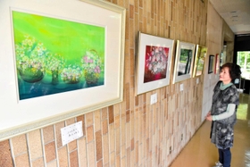 季節の花を描いた幻想的な作品と島田三恵子さん=洲本市民交流センター 季節の花を描いた幻想的な作品と島田三恵子さん=洲本市民交流センター