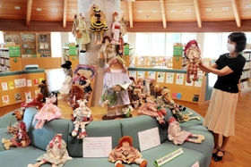 円形ソファに展示したカントリードールと制作した富長寛子さん=洲本市立五色図書館 円形ソファに展示したカントリードールと制作した富長寛子さん=洲本市立五色図書館