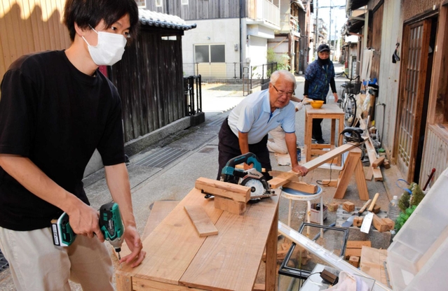 改修に取り組む福良町づくり推進協議会の河野博さん(中央)と大学生=南あわじ市福良乙