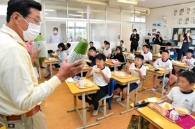 森久則さん(左)の説明を聞きながら、青パパイアを味わう児童=津名東小学校 森久則さん(左)の説明を聞きながら、青パパイアを味わう児童=津名東小学校