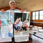 現地で自ら撮影した写真を持つ西村さん=洲本市