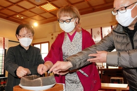 こんにゃくに針を刺す参拝者ら=洲本市本町4 こんにゃくに針を刺す参拝者ら=洲本市本町4