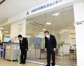 出前市役所のシャッターをおろし、頭を下げる門康彦市長(左)と松本英志議長=淡路市志筑新島 出前市役所のシャッターをおろし、頭を下げる門康彦市長(左)と松本英志議長=淡路市志筑新島