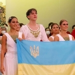 イワノワさん(左)とシュリヒテルさん(右)が、共演したダンサーと共にウクライナ国旗を掲げた=淡路市野島大川