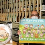 ゴーアラウンド用の缶バッジと、ポスターを持つ矢野さん=洲本市本町4