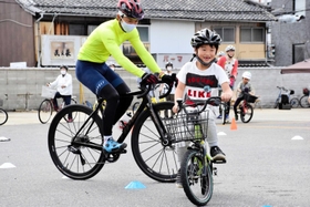 自転車のプロ選手、竹之内悠さんに乗り方を教わる子ども=洲本市栄町1 自転車のプロ選手、竹之内悠さんに乗り方を教わる子ども=洲本市栄町1