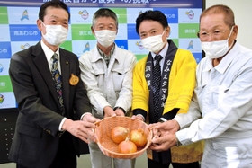 宇宙から戻った種をもとに育てたタマネギを守本憲弘市長から受け取る(右から)浪江町タマネギ生産組合顧問の阿部仁一さん、金山信一浪江町農林水産課長、松本善郎組合長=南あわじ市役所 宇宙から戻った種をもとに育てたタマネギを守本憲弘市長から受け取る(右から)浪江町タマネギ生産組合顧問の阿部仁一さん、金山信一浪江町農林水産課長、松本善郎組合長=南あわじ市役所