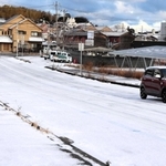凍結した道路を車が慎重に走った=25日朝、淡路市志筑