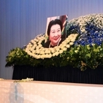 偲ぶ会で献花をする人=神戸市東灘区内