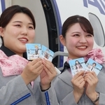 25日から配布する「鬼滅の刃」のステッカーをPRするANAの客室乗務員=伊丹空港