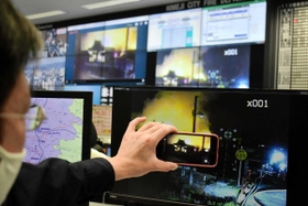 スマートフォンで撮影した映像が消防局のモニター(奥)に中継される=姫路市三左衛門堀西の町、市消防局 スマートフォンで撮影した映像が消防局のモニター(奥)に中継される=姫路市三左衛門堀西の町、市消防局