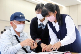 高齢者にワクチンの予約システムを解説する高校生=姫路市安田4 高齢者にワクチンの予約システムを解説する高校生=姫路市安田4