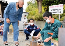 明珍巧さん(左)の指導で火箸作りを体験する生徒=姫路市下手野2 明珍巧さん(左)の指導で火箸作りを体験する生徒=姫路市下手野2