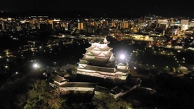 ライトアップで照らされる夜の姫路城大天守。奥には市街地の夜景が広がる(姫路市提供) ライトアップで照らされる夜の姫路城大天守。奥には市街地の夜景が広がる(姫路市提供)