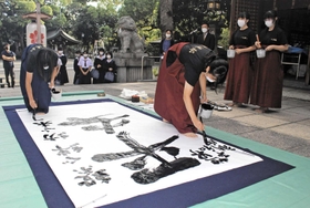 「平安」の文字を中心に揮毫する賢明女子学院高校の生徒=姫路市本町 「平安」の文字を中心に揮毫する賢明女子学院高校の生徒=姫路市本町