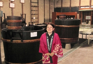 昭和30年代ごろまで酒造りで使っていた道具を展示する旧酒蔵で、今後の意気込みを語る灘菊酒造の川石光佐社長=姫路市手柄1
