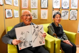 丁寧に描かれた植物などの作品と石原四郎さん(左)、佳津子さん=加西市北条町西高室 丁寧に描かれた植物などの作品と石原四郎さん(左)、佳津子さん=加西市北条町西高室