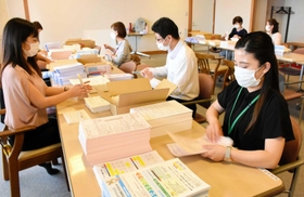 60~64歳の接種券や関連資料を封入するスタッフたち=加西市健康福祉会館 60~64歳の接種券や関連資料を封入するスタッフたち=加西市健康福祉会館