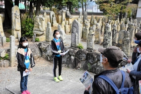 さまざまな石仏や本堂などについて説明する児童たち=羅漢寺 さまざまな石仏や本堂などについて説明する児童たち=羅漢寺