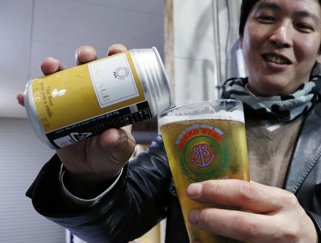 このほど発売した缶ビールをグラスに注ぐ中島学専務=神戸市北区有野町有野