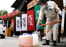 テークアウトを始めた金泉をポリタンクに注ぐ従業員=神戸市北区有馬町池の尻、有馬温泉太閤の湯