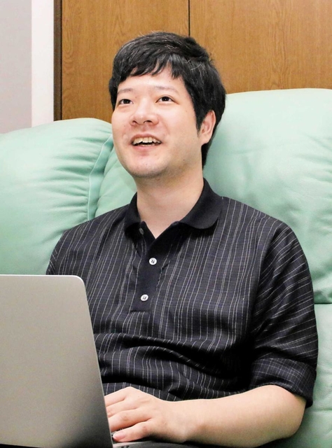 自宅の一室でノートパソコンを開くK.S.ロジャースの民輪一博社長=神戸市長田区