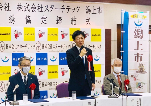 連携協定の締結式であいさつするケンミン食品の高村祐輝社長(中央)=2020年11月、秋田市(同社提供)