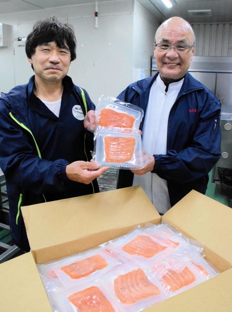純神戸産のスモークサーモンを手にする「すまうら水産」の森本明代表(左)と「オーシャンベスト」の門田和士社長=神戸市兵庫区