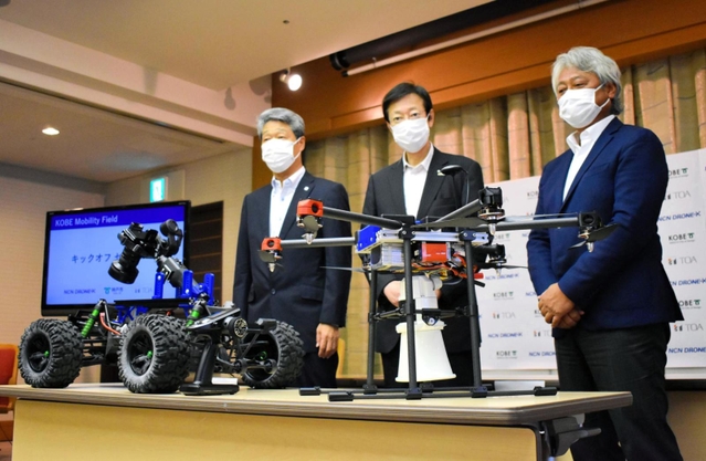 実証実験に使うドローンとロボットを前にする(右から)NCNの沖貴博社長、久元喜造神戸市長、TOAの竹内一弘社長=神戸市中央区加納町6、神戸市役所
