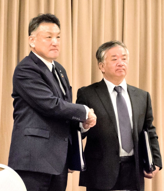 M&Aの調印式で握手する日工の辻勝社長(左)と宇部興機の阿部正義前社長=1日午前、山口県宇部市(日工提供)