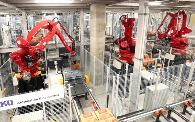 コカ・コーラのボトルが入ったケースをパレットに積み上げるアームロボット=明石市大久保町西脇(撮影・辰巳直之)