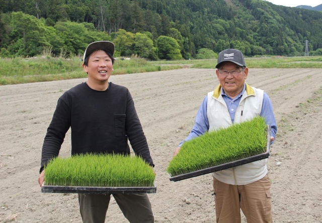 田植え前の田んぼで苗を手にする吉田勝博さん(左)と馬躰哲郎さん=姫路市安富町名坂