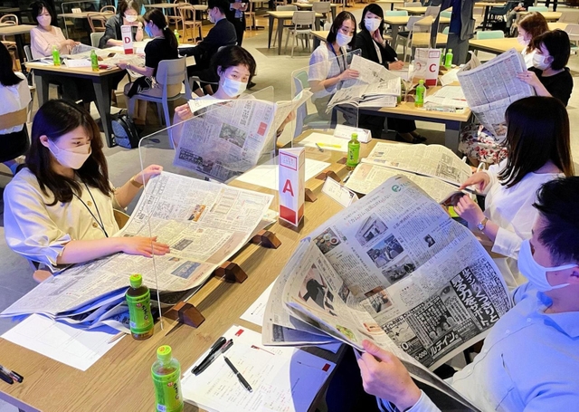 ワークショップで、新聞から気になる情報を探す受講者=大阪市北区梅田1