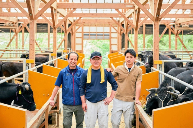 宍粟牛の野球グラブを開発したミズノテクニクス波賀工場の西中正登さん(左)=宍粟市波賀町道谷、岸本牧場(ミズノ提供)