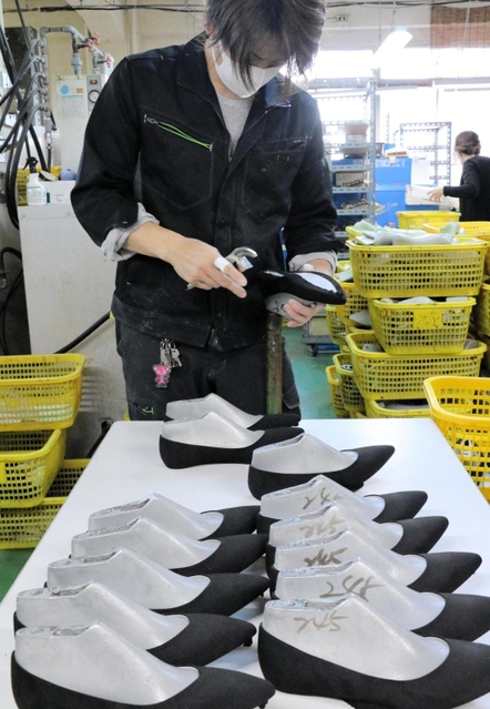 縫製された靴のアッパー(足を覆う部分)を成型する従業員=神戸市長田区細田町2、サンナイト