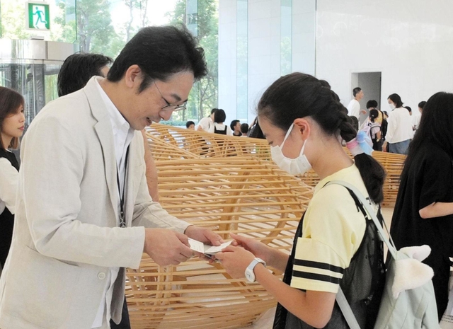 社員の子どもと名刺交換する鈴木信輝社長(左)=神戸市中央区港島中町6、ワールド