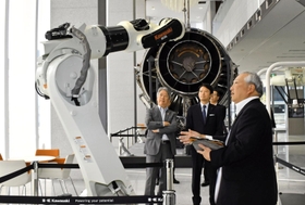 ロボット製品の説明を受ける斎藤元彦知事(左から2人目)と川崎重工業の橋本康彦社長(左端)=明石市川崎町1、川崎重工業明石工場