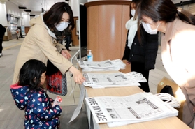 防災土産袋を手に取る駅利用者ら=JR神戸駅 防災土産袋を手に取る駅利用者ら=JR神戸駅